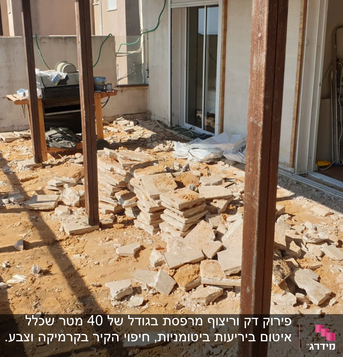 שקיות חומרי בנייה וערימת אריחים על רצפה